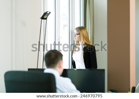 Young business people at office, business woman seeing the future through the window