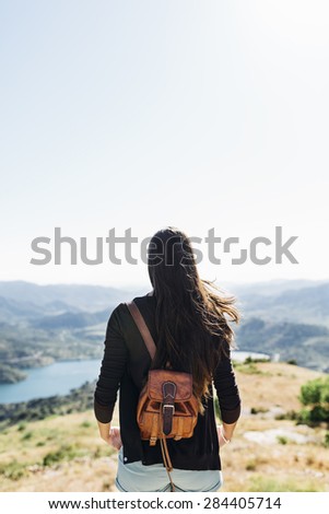 young woman on top of a mountain with view