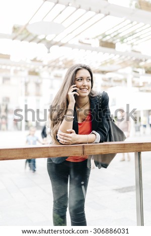 Portrait of a beautiful young businesswoman standing outside using mobile phone