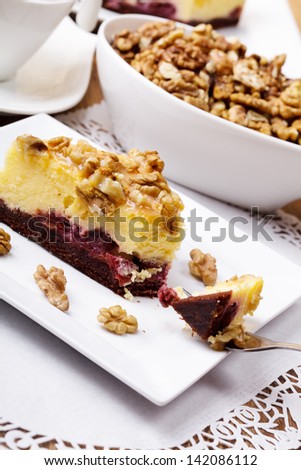 Cheesecak with a cap of coffee or tea (Selective Focus, Focus on the front upper edge of the cake) A plate of cake while eating.