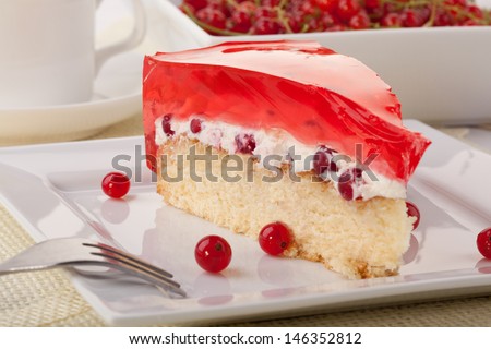 homemade cake with jelly, whipped cream and fresh redcurrant