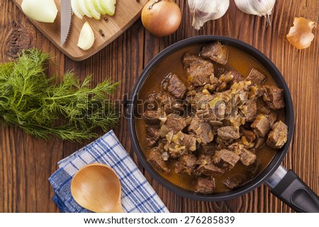 Preparing beef stew - wooden background