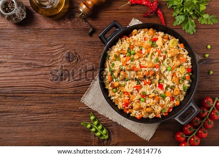 Fried rice with chicken. Prepared and served in a wok. Natural wood in the background. Top view. Сток-фото © 