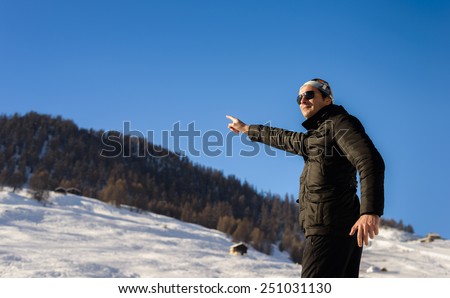 Man pointing into the blue sky at ski resort