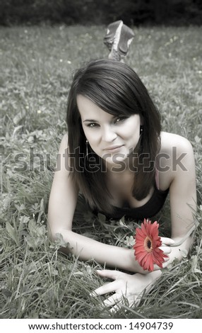 Beautiful Lady With Red Flower Laying On The Grass