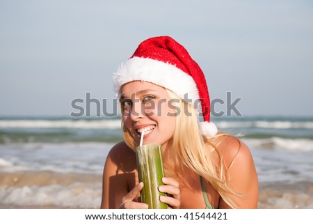 Happy beautiful woman in the christmas hat on the beach
