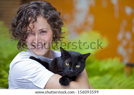 Portrait Of Smiling Woman with her cat looking at the camrea