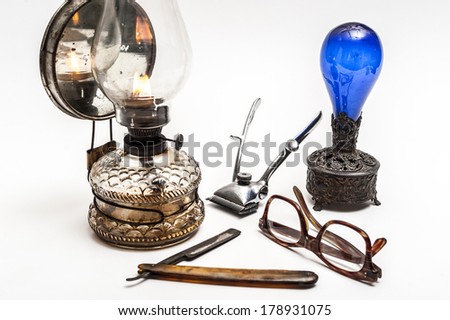 Old and worn rusty razor, oil lamp, metal trimmer, air freshener and glasses on a white background