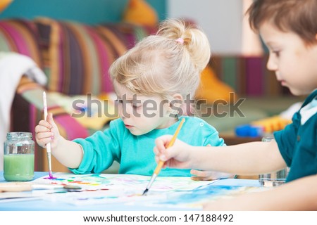 Kids drawing with watercolor paints