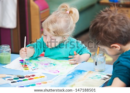 Kids drawing with watercolor paints