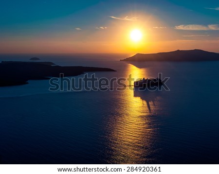 Cruise ship silhouette in sunset light with a few islands on background