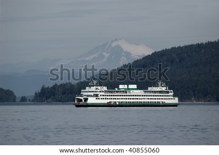 Ferry sailing through Puget sound with Mt. Baker on a background