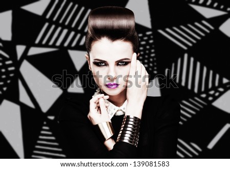 the sexy strict woman with violet lips and a fashionable  hairstyle poses in studio on creative background