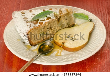 Slice of pear pie with honey on red wooden table From series Summer desserts