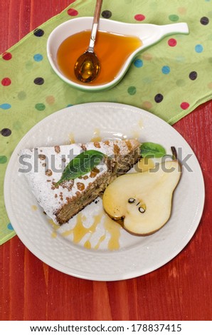 Slice of pear pie with honey on red wooden table From series Summer desserts