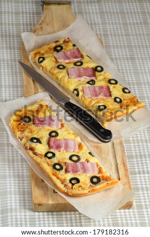 Homemade pizza with ham, cheese and olives. Selective focus. From the series Making homemade pizza