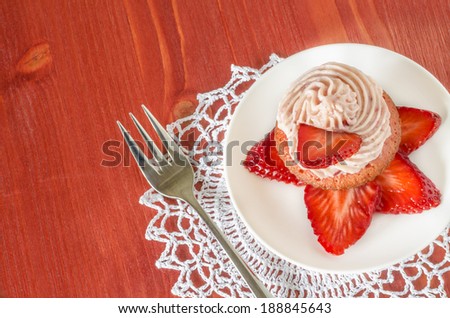 Strawberry cupcake with butter cream decorated with slices of fresh strawberries From series Summer desserts