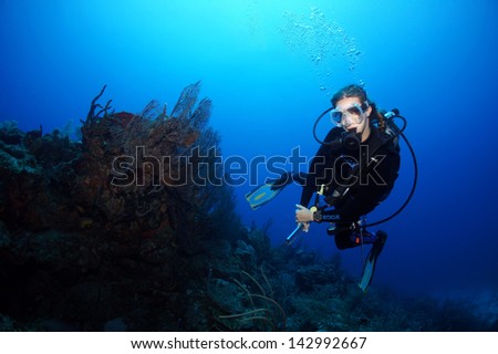 Female blond scuba diver swimming over the coral reef - Akumal, Riviera Maya - Mexico