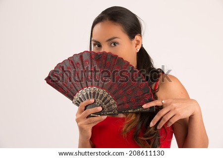 Beautiful woman with fan covering her face