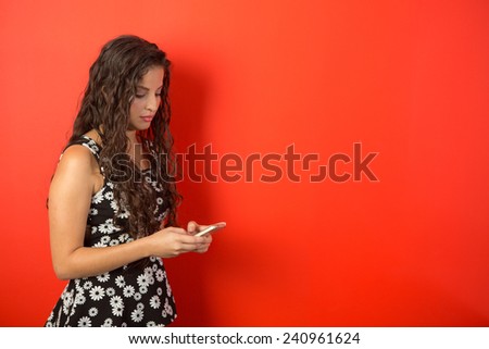 Beautiful woman executive sending a text message in an office