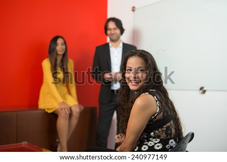 Three executives working at a business meeting, woman looking a