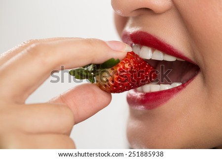 Woman biting a strawberry