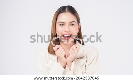 Young smiling woman holding Invisalign braces in studio, dental healthcare and Orthodontic concept Stock foto © 
