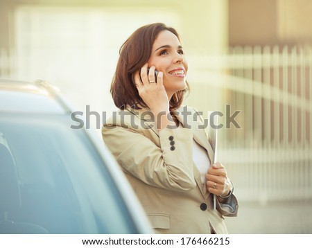 Modern mid adult businesswoman talking on the phone outdoors