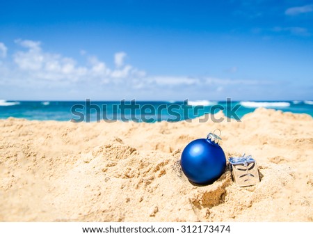 Merry Christmas and Happy New Year background with gift and ball on the tropical beach near ocean in Hawaii