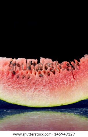 Refreshing watermelon slice with reflection isolated on black background