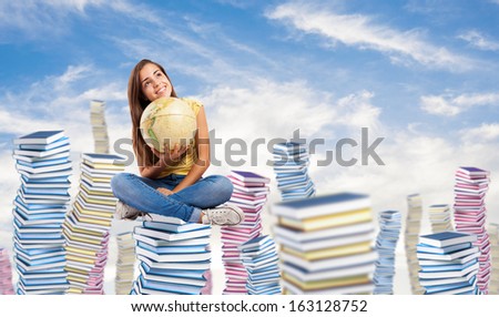 pretty young student holding a earth globe sitting on a big books pile