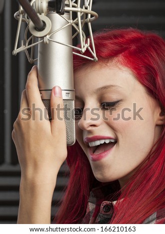 young pretty woman recording on audio studio