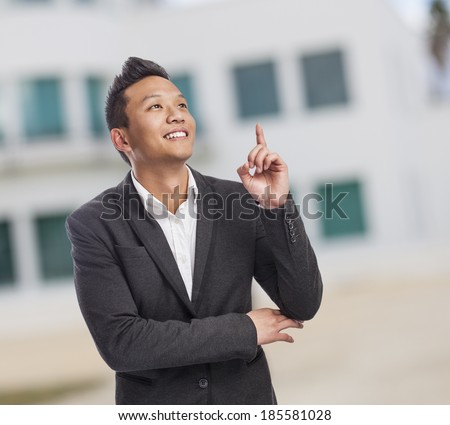 handsome young asian man pointing up with finger