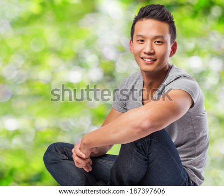handsome young asian man sitting at park