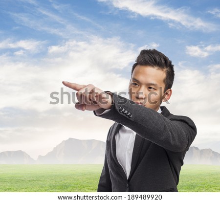 Handsome young business asian man pointing up