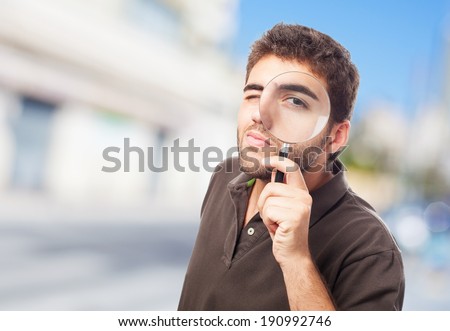 young man looking through magnifying glass