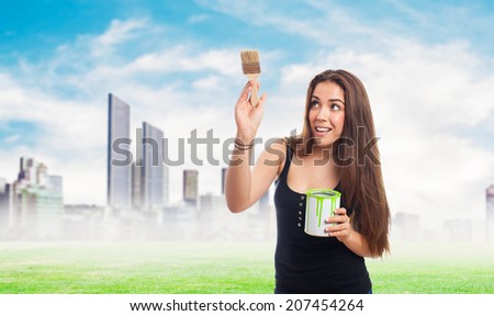 portrait of young woman painting and holding a paint can