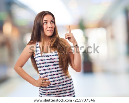 portrait of a young woman pointing up with finger