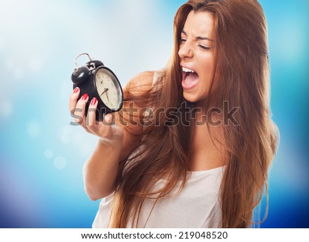 portrait of a young student screaming to alarm clock