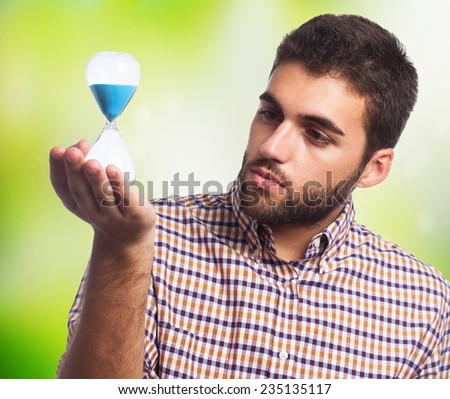 portrait of a young man holding a sand timer