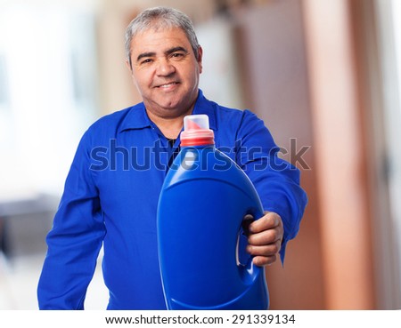 portrait of a mechanic holding an oil bottle