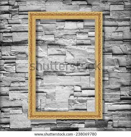 Antique gold frame on stone wall background ,gold picture frame on sandstone brick wall Surfaced background