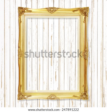Antique gold frame on white wooden wall ;. Empty picture frame on white wooden wall.