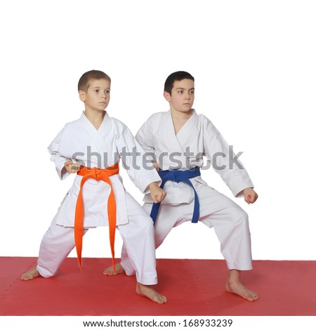 Athletes with a blue belt and orange belt stand in rack