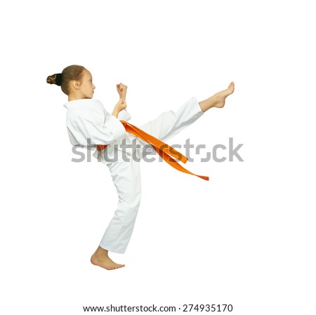 A girl with a red belt makes high kick karate