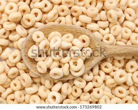 healthy cereal rings and wooden spoon on background