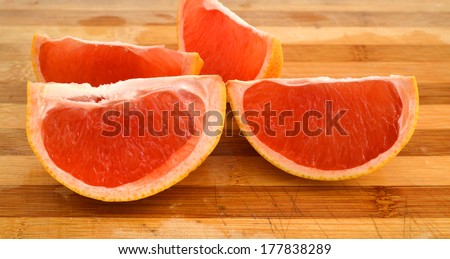 Sliced red grapefruit isolated on wooden board