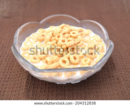 healthy cereal rings in glass bowl on brown background