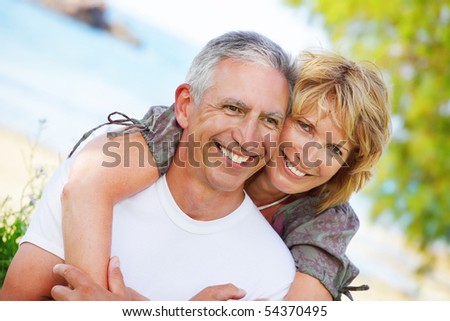 Close-up portrait of a mature couple smiling and embracing.