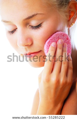Beautiful young woman removing make-up. Isolated over white background.